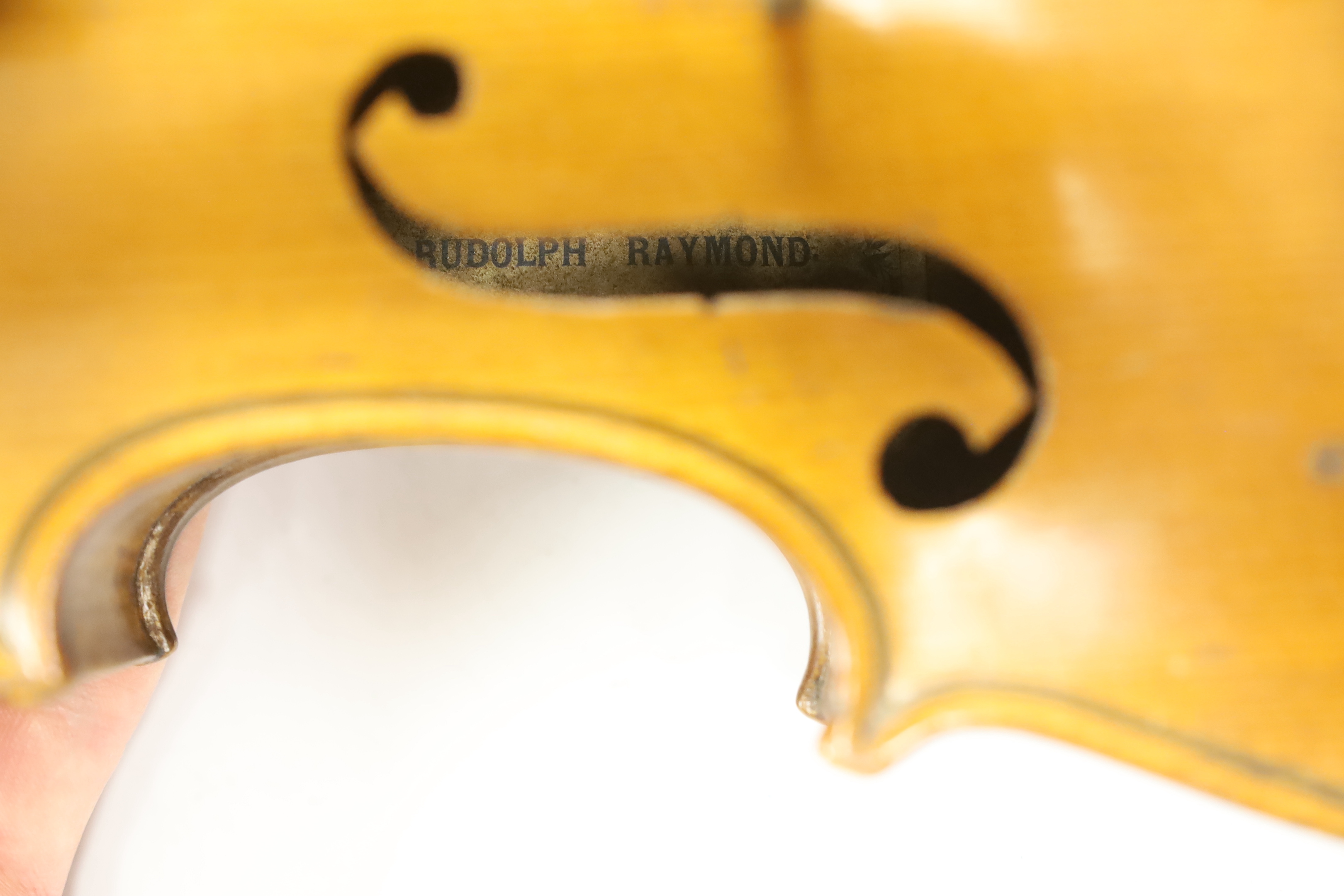 A cased early twentieth century violin by Rudolph Raymond, with maker’s label inside the body stating ‘made 1904’, body 36cm, in a good case with a label for W.E. Hills & Sons, Violin Makers, 140 New Bond St. London